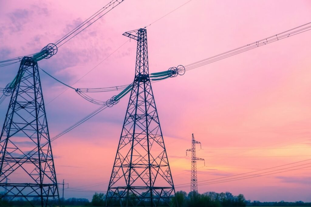 Electricity transmission pylons against the sky, illustrating the power-grid infrastructure needed to connect renewable generation