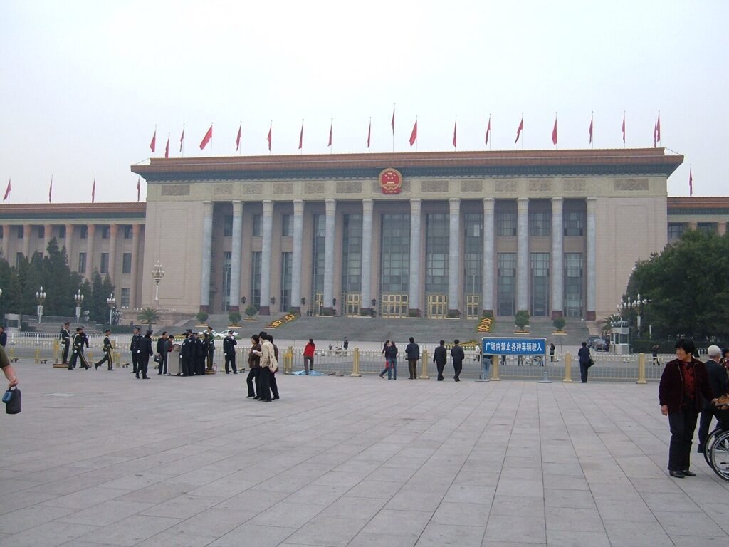 Archival exterior view of the Great Hall of the People in Beijing, with flags and pedestrians in the square; photographed in 2007, not the October 2026 Communist Party plenum.
