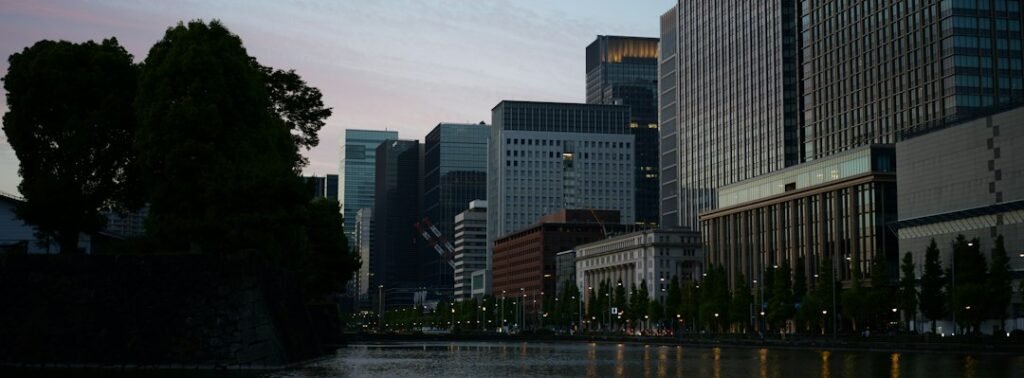 Illustrative modern city buildings at twilight; not a photograph of the Bank of Japan policy meeting.