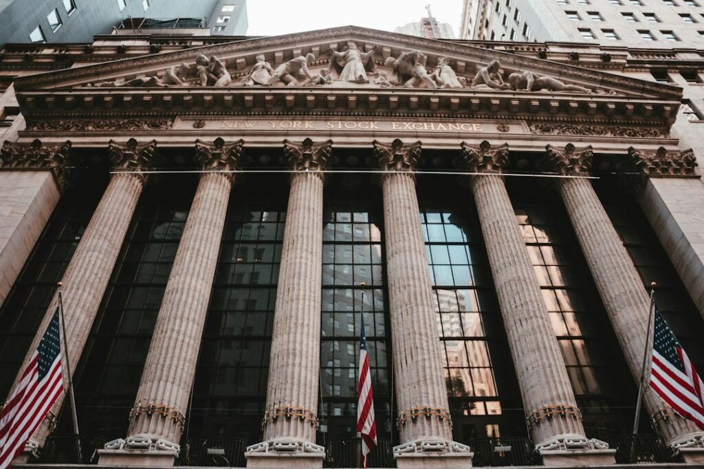 Exterior of the New York Stock Exchange on Wall Street with United States flags; illustrative photo, not a depiction of the October 2026 GDP announcement