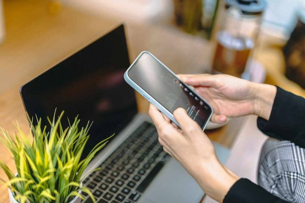 Illustrative photograph of a person holding a smartphone beside a laptop, representing online search and referral traffic; not a Reddit screenshot.
