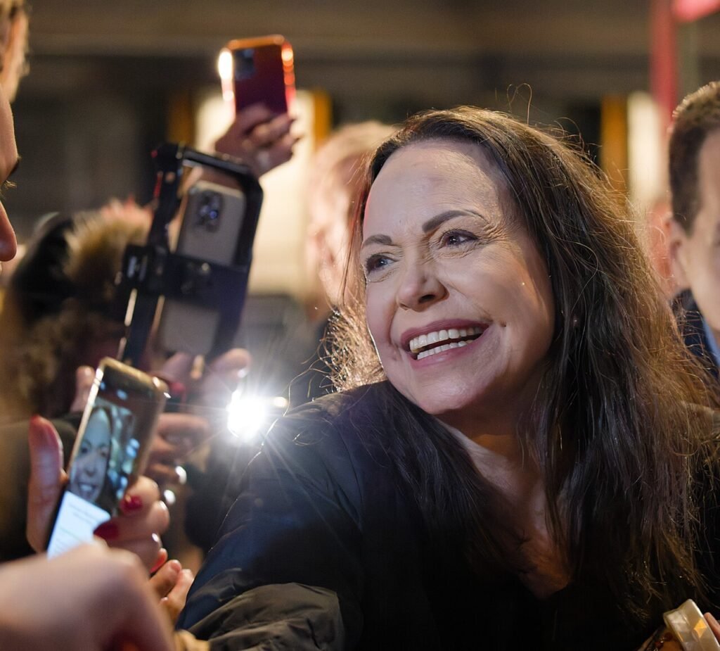 Archival December 2025 photograph of María Corina Machado smiling while greeting supporters in Oslo; not her October 2026 return to Venezuela.