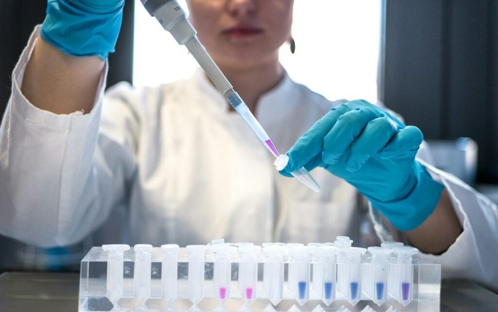 Illustrative photograph of a laboratory scientist pipetting samples; not an image of IAVI's Bundibugyo vaccine or the Congo outbreak